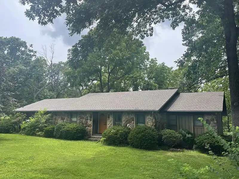 Small home with new shingles installed by Hollis Roofing & Restoration